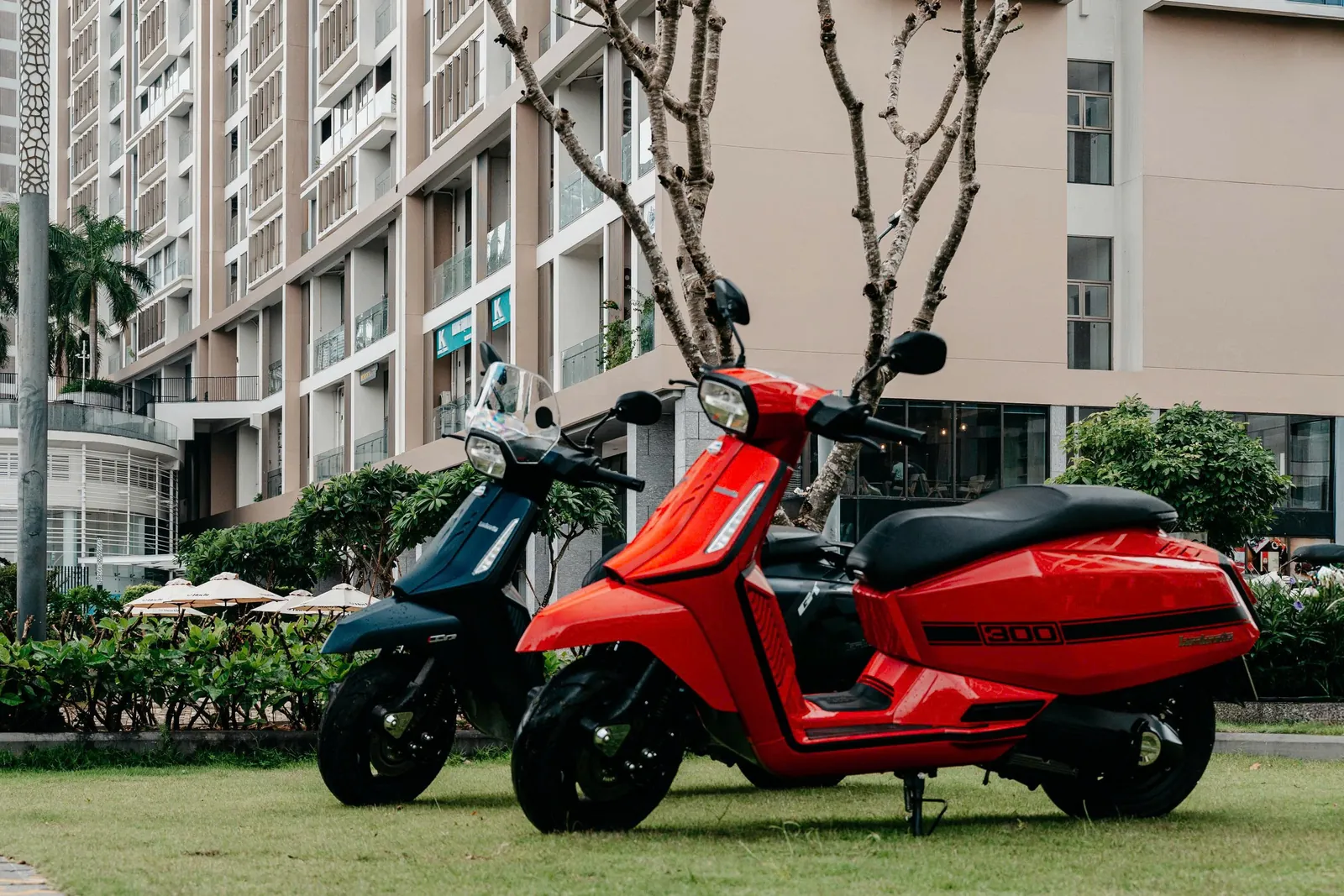 Lambretta X300 GT xanh navy và X300 đỏ đậu cạnh nhau trên bãi cỏ